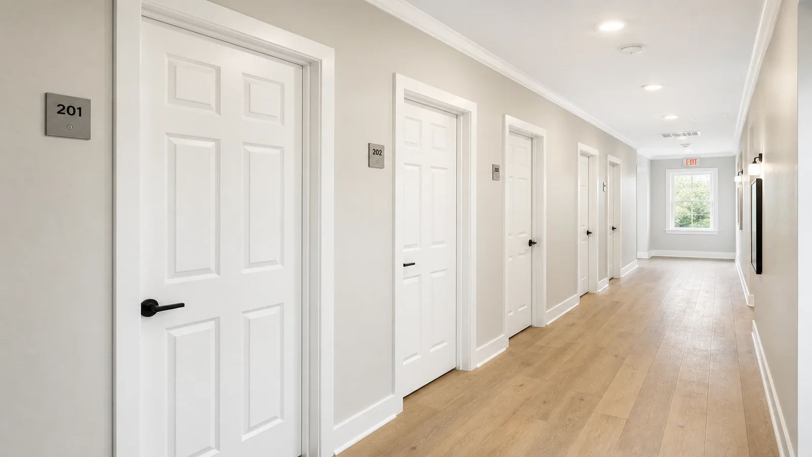Newly installed white primed interior doors in a US multifamily apartment corridor