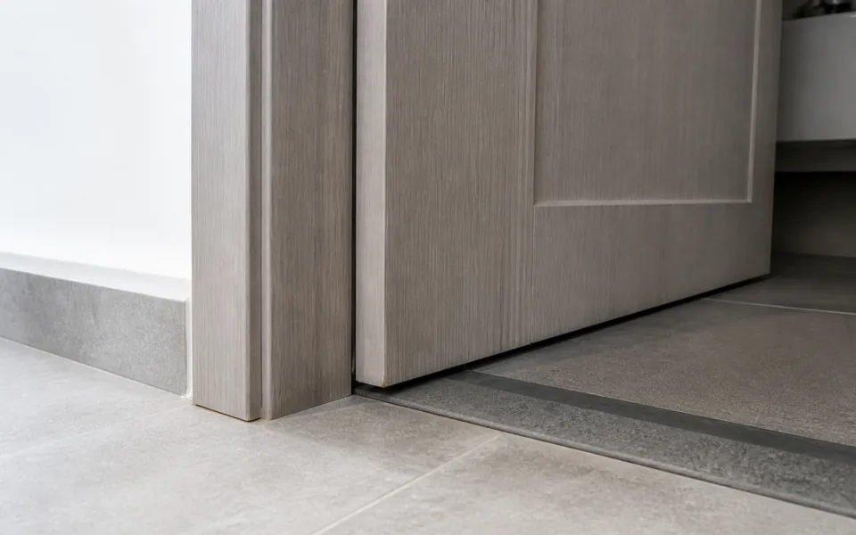 Close detail of a WPC bathroom door bottom edge, frame and threshold junction